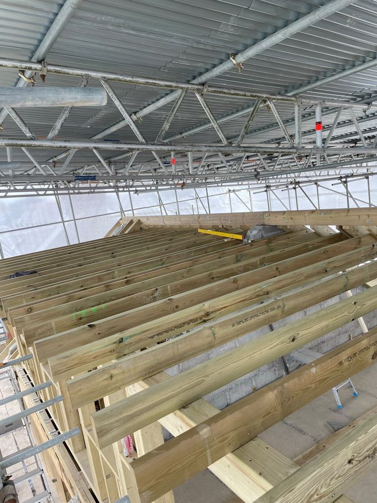 Timber roof joists under construction, scaffold visible