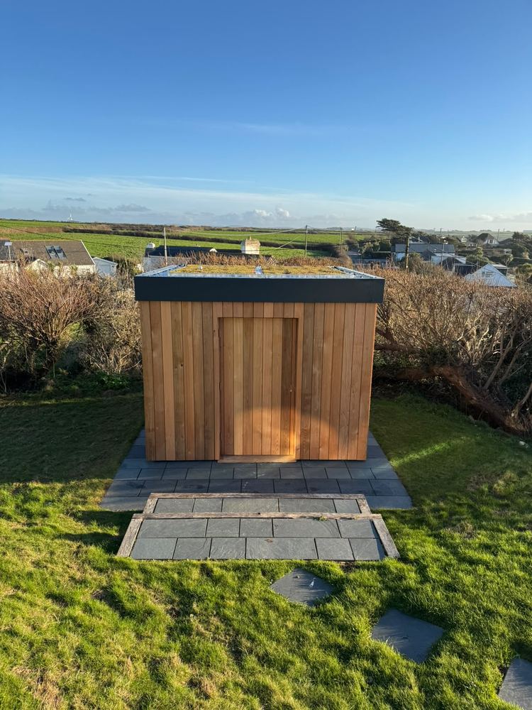 Modern cedar-clad garden building with green roof